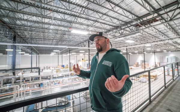 Man gesturing while giving a tour inside a warehouse